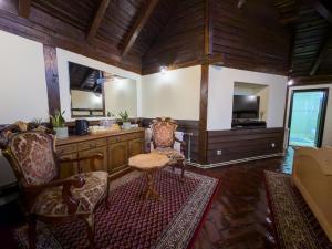 ein Wohnzimmer mit Tisch, Stühlen und Fernseher in der Unterkunft Etno Sobe in Smederevo