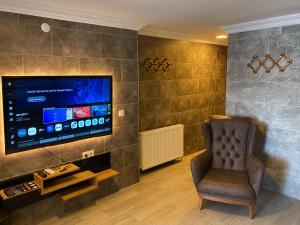 a living room with a chair and a flat screen tv at Reco Luxury Suite in Kavaklıdere