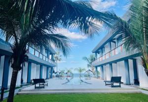 a building with palm trees in front of it at Grand Bay Hotel in Arugam Bay
