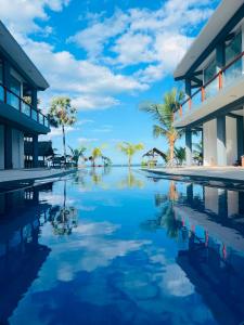 a pool in front of a building with palm trees at Grand Bay Hotel in Arugam Bay