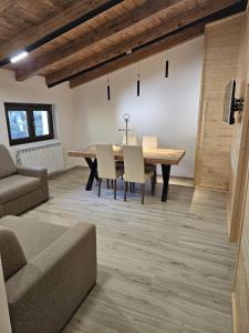 a dining room with a wooden table and chairs at Dimora nel bosco in Lorica