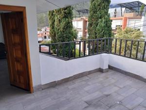 a balcony of a building with a door and trees at Roxel Home in Baños