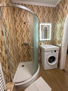 a bathroom with a shower and a washing machine at Euro Apartman in Debrecen +63 photos