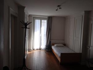a bedroom with a bed and a large window at Chambre B 1 étage avec balcon in Biel