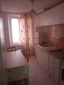 a kitchen with white cabinets and a sink and a window at Chambre B 1 étage avec balcon in Biel