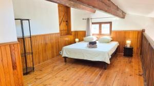 a bedroom with a bed and wooden floors at Maison Aqua Bella - Terrasse - BBQ - 8pers in Contes