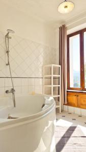 a white bath tub in a bathroom with a window at Maison Aqua Bella - Terrasse - BBQ - 8pers in Contes +25 photos