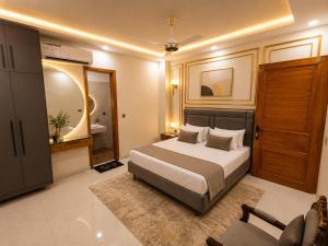 a bedroom with a bed and a chair in it at City rooms in Karachi