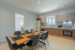 a kitchen and dining room with a wooden table and chairs at Aspasia House in Platanias
