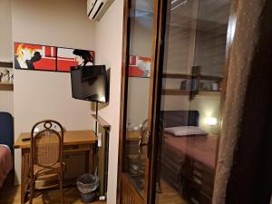 a room with a desk and a television and a room with a bed at B&B Paolo e Francesca in Rimini