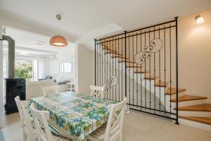 a dining room with a table and a staircase at Lavender house with shared pool in Herceg-Novi