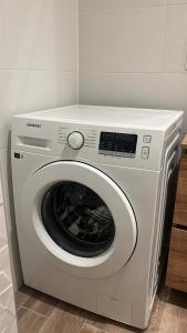 a white washing machine sitting in a room at Charmant studio au coeur du centre ville historique - Les tailleurs in Sélestat