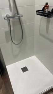 a white shower with a hose in a bathroom at Charmant studio au coeur du centre ville historique - Les tailleurs in Sélestat +43 photos