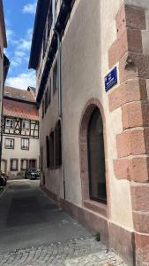 a building with a blue sign on the side of it at Charmant studio au coeur du centre ville historique - Les tailleurs in Sélestat