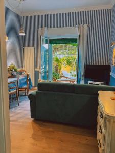 a living room with a couch and a table and a window at Siwa Home Experience in Anzio