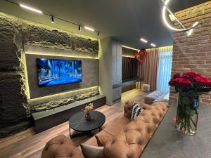 a living room with a couch and a tv on a wall at MOCCA Lux Suite in Bitola