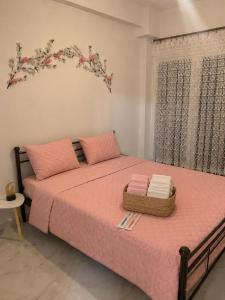 a bedroom with a pink bed with a basket on it at Cherry Blossom Apartment in Xanthi