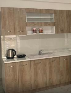 a kitchen with wooden cabinets and a sink at Cherry Blossom Apartment in Xanthi