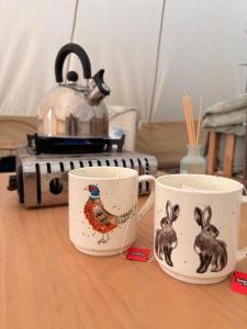 two coffee cups with a turkey and rabbits on them at Hedgerow hideaway in Llanvetherine