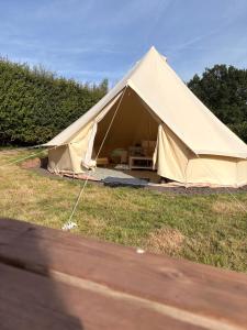 a large tan tent in a grass field at Hedgerow hideaway in Llanvetherine