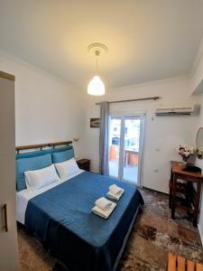 a bedroom with a blue bed with two towels on it at Anna Garden Sidari in Sidari