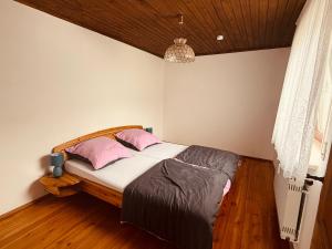 a bedroom with a bed with pink pillows at Ferienwohnung Bayerischer Wald in Zwiesel