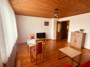 a living room with a table and chairs and a television at Ferienwohnung Bayerischer Wald in Zwiesel