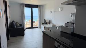 a kitchen and living room with a view of the ocean at Canelas 22 in Sanxenxo