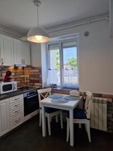 a kitchen with a table and chairs and a microwave at Ultracentral Mangalia seaside deluxe apartament in Mangalia