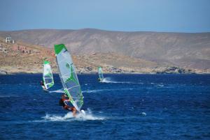 two people are windsurfing in the water at Chaniotis Studios in Kalafatis
