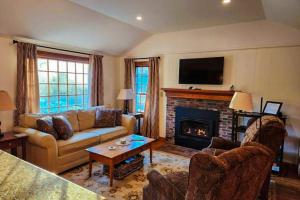 a living room with a couch and a fireplace at Gingerbread Cottage in Sugar Hill