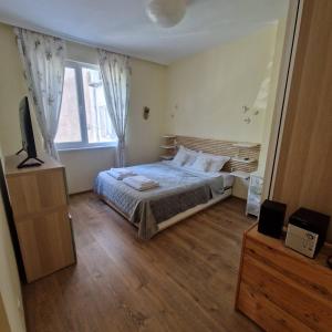a bedroom with a bed and a television in it at Blue Dreams - City Center Burgas in Burgas