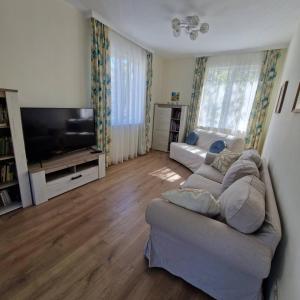 a living room with a couch and a flat screen tv at Blue Dreams - City Center Burgas in Burgas