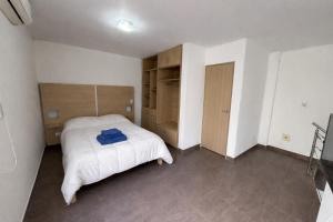 a bedroom with a white bed and a closet at Complejo del jaguel Reserva del Bosque in Santa Teresita