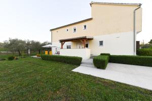 a building with a grassy yard in front of it at Apartment Sanja in Zadar