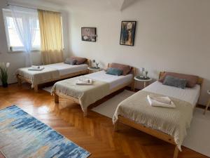 a room with three beds and a rug at Rooms delux muro in Split