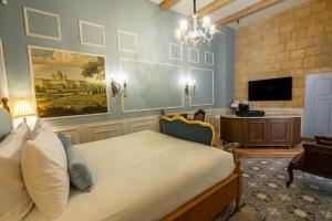 a bedroom with a large bed and a tv at The Vincent Boutique Hotel, BW Premier Collection in Valletta
