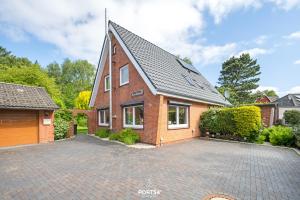 a brick house with a driveway in front of it at Ferienwohnung Windjammer 5 St Peter-Ording in Sankt Peter-Ording +26 photos