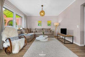 a living room with a couch and a tv at Ferienwohnung Windjammer 5 St Peter-Ording in Sankt Peter-Ording