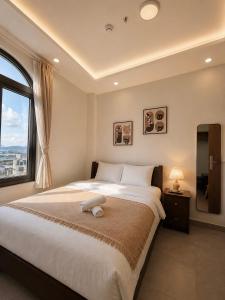 a bedroom with a large bed and a window at Amelia House - Boutique Hotel in Khu Chi Lăng