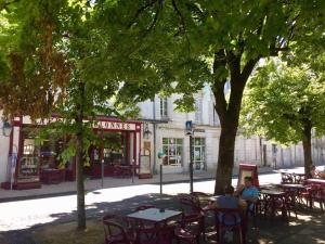 a group of people sitting at tables in a park at Fontaine Studio Appartement in Ribérac +14 photos