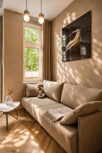 a living room with a brown couch and a window at Stylish City Center Escape- Where Modern Elegance Meets History in Trier