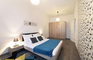 een slaapkamer met een groot bed en een blauwe deken bij Block Apartment in Zagreb