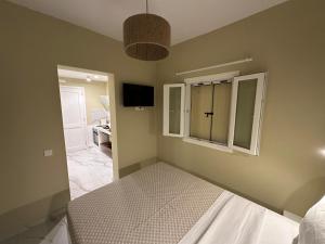 a bedroom with a bed and a window at Pelekouda Coastal Apartments in Pollonia