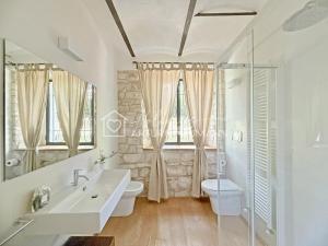 a bathroom with a sink and a toilet and a mirror at 207 - VILLA FERNANDA - Bilocale di charme al piano terra immerso nel verde, in centro e a pochi passi dal mare SPIAGGIA AL WHITE BEACH CLUB IN OMAGGIO dal lun al ven dal 24-08 in Sirolo