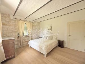a bedroom with a bed and a stone wall at 207 - VILLA FERNANDA - Bilocale di charme al piano terra immerso nel verde, in centro e a pochi passi dal mare SPIAGGIA AL WHITE BEACH CLUB IN OMAGGIO dal lun al ven dal 24-08 in Sirolo