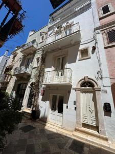 a white building with a door and a balcony at D'Aaragona 56 in Conversano