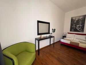 a room with a bed and a chair and a mirror at D'Aaragona 56 in Conversano