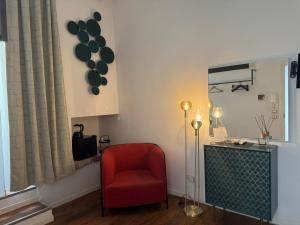 a living room with a red chair and a mirror at D'Aaragona 56 in Conversano +15 photos