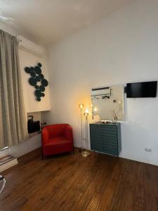 a living room with a red chair and a window at D'Aaragona 56 in Conversano
